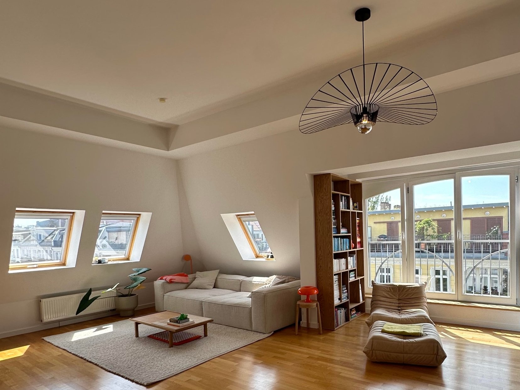 Bright practice room with a sofa, bookshelf and large window front